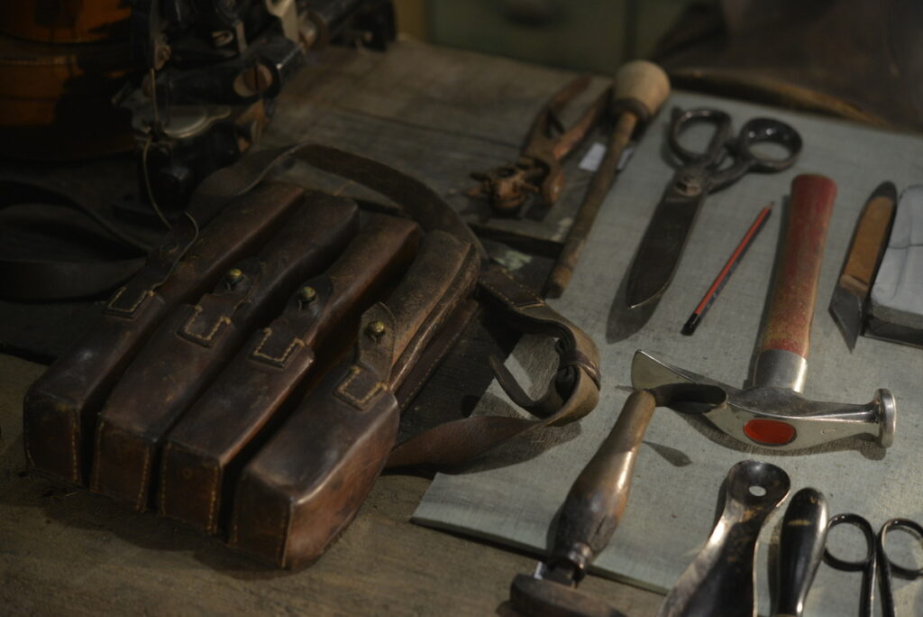 Radni sto sa kožnom torbom i starim alatom na drvenoj površini
